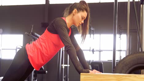 determinada hermosa mujer caucásica haciendo flexiones en una caja de madera 4k