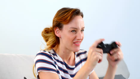 mujer jugando un juego de joystick en el sofá 4k