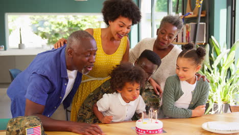 Multi-Generation Family With Military Father Celebrating Son&#039;s Birthday With Cake At Home