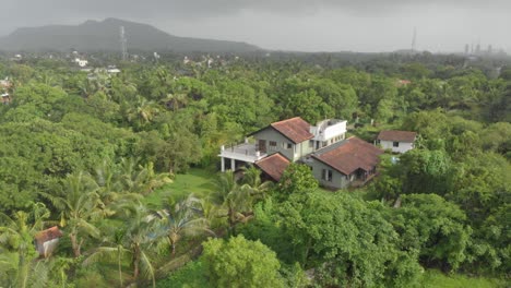 Kreisförmige-Drohnenaufnahme-Eines-Großen-Ferienhauses-Mit-Swimmingpool-In-Der-Indischen-Landschaft