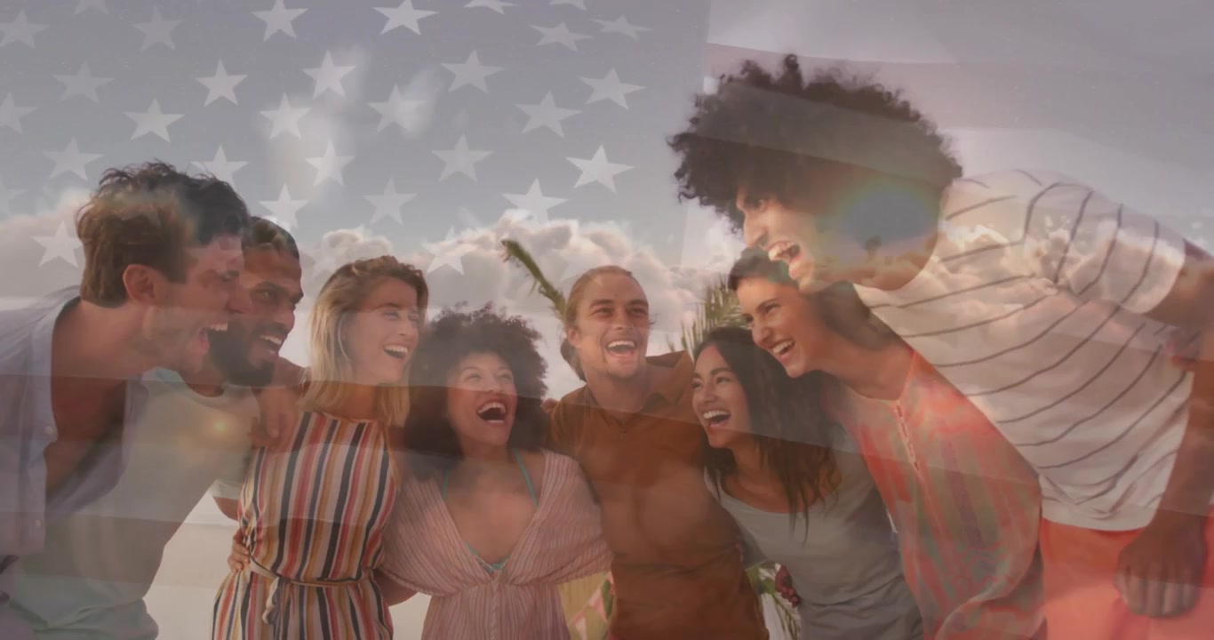 Eight friends leaning in and laughing at beach as flag overlay fading fueling patriotic marketing