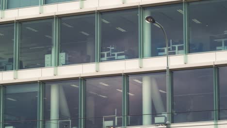 Large-glass-windows-building-facade-in-Prague,-Czech-Republic---Pan-shot