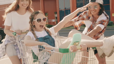 teenage girls having fun with a shopping cart