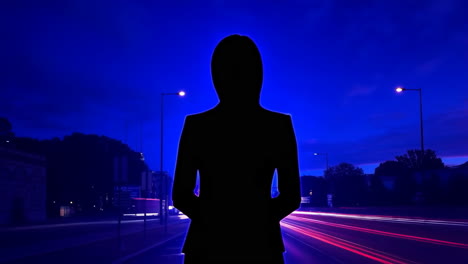 Silhouette Against Night City Road with Light Trails