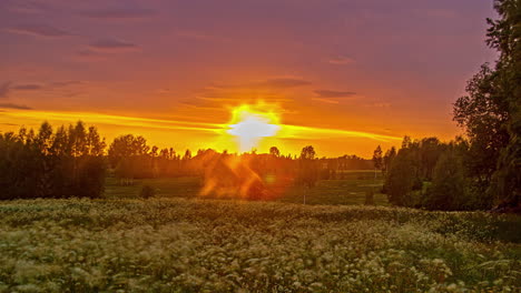 Cielo-Dramático-Al-Atardecer-Con-Sol-Rojo-Brillando-Sobre-Un-Campo-Rural