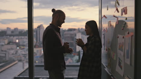 Smiling-couple-silhouette-talking-at-sunset-close-up.-Flirting-colleagues-dating