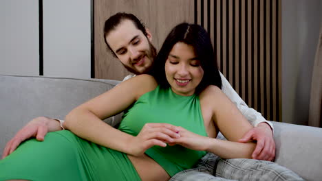 una pareja besándose en el sofá.