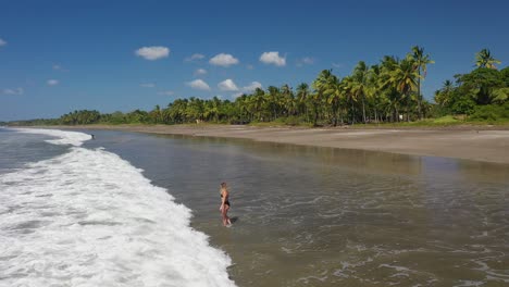 Mujer-Vadeando-Las-Olas-En-Los-Trópicos-En-Una-Hermosa-Playa