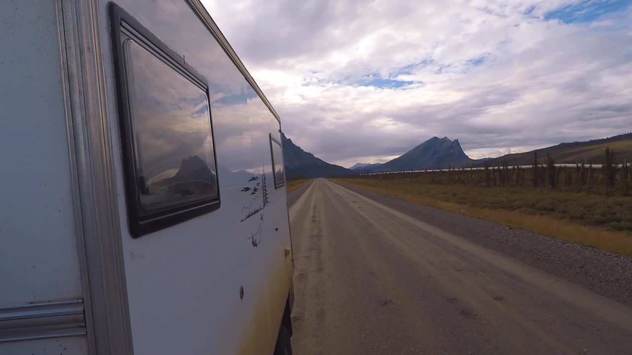 vista trasera desde el lado de una autocaravana conduciendo por la autopista dalton cerca del oleoducto de alaska