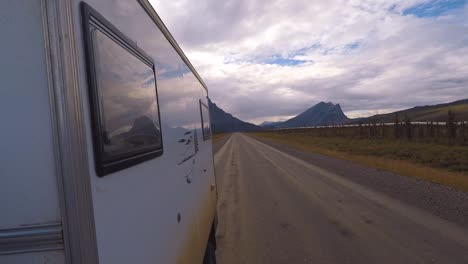 rear view from the side of a motorhome driving on the dalton highway close to the alaska pipeline