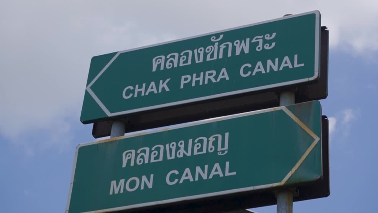 Handheld shot of boat sign along Chao Phraya River in the day in Bangkok, Thailand
