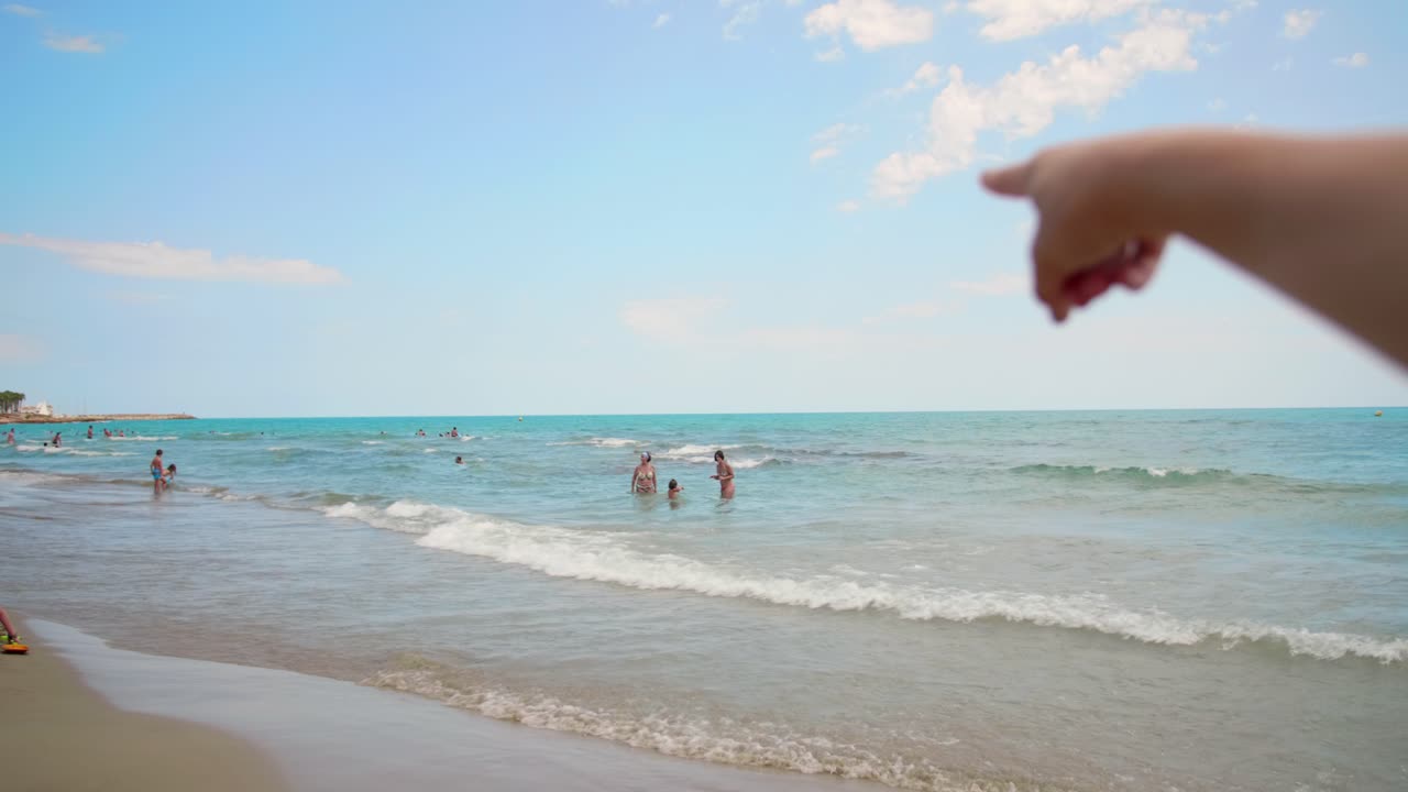 바다 해변을 가리키는 여자의 손