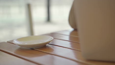 cropped view of man drinking tea and using laptop in cafe