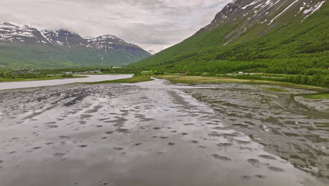 Nordkjosbotn-Norway-Aerial-v6-cinematic-low-level-drone-flyover-marshy-plain,-narrow-inlet-where-balsfjord-meets-nordkjoselva-river-surrounded-by-mountain-valleys---Shot-with-Mavic-3-Cine---June-2022