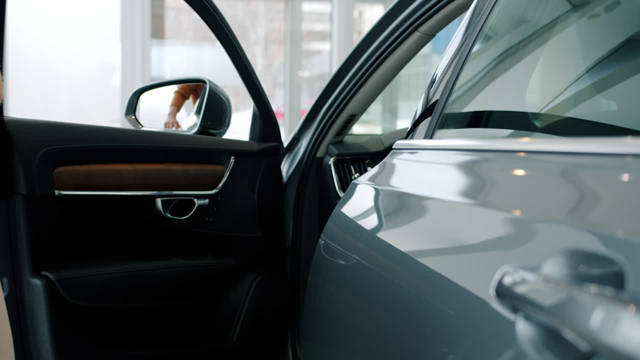 mujer mirando un coche en una sala de exposiciones