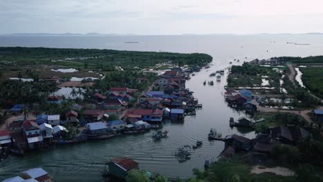 traditional fishing village in an estuary on the south coast of cambodia with boats traveling, drone aerial