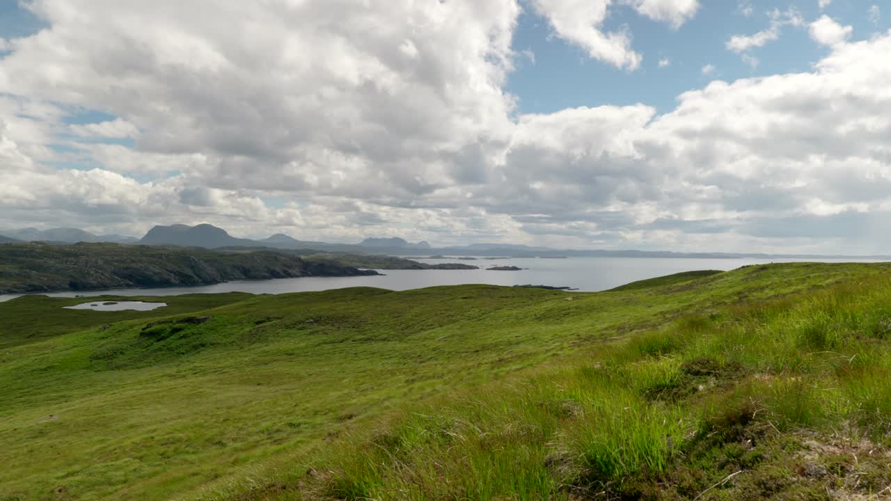 한다 섬에서 촬영된 무성한 푸른 잔디와 천천히 움직이는 구름이 있는 산의 넓은 풍경