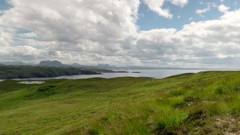 a wide landscape view of the mountains with lush green grass and slowly moving clouds, filmed on handa island