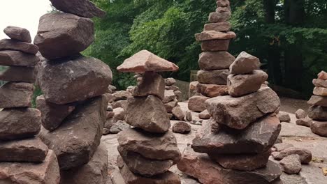 close up zoom out of small rock balancing on top of stacked rocks on table