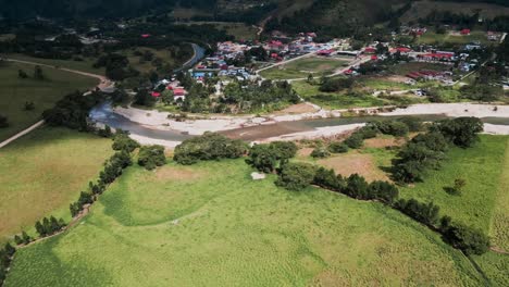 Aerial-shot-of-a-river-in-Oxapampa-during-a-sunny-day-with-the-jungle-in-the-background