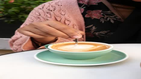 woman enjoying a latte at an outdoor cafe