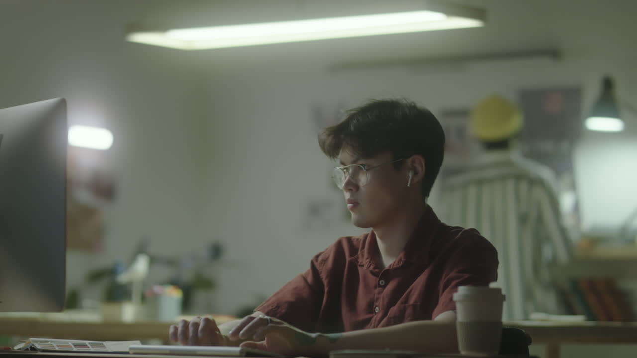 Young Man Working on Computer in Office at Night
