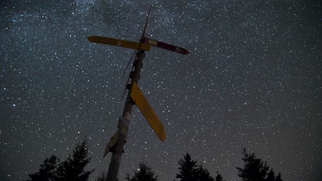 timelapse of the nightsky with a signpost