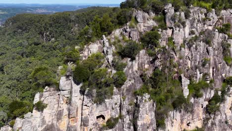 drone footage captures the lush greenery and striking rock formations of nimbin rocks under bright daylight