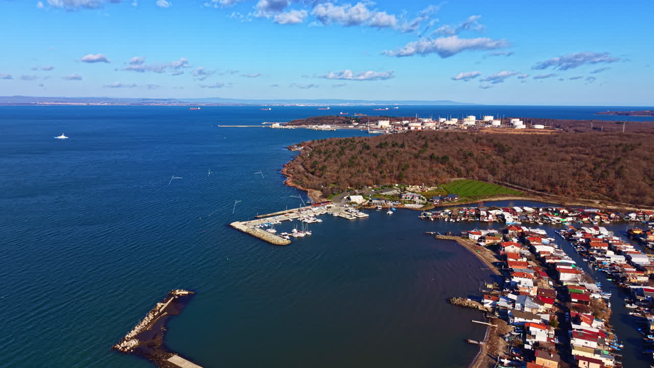 Vista costiera che mostra case in riva all'acqua di giorno, con barche e terra distante sullo sfondo