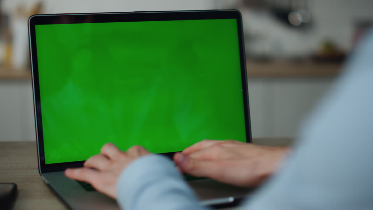 manos escribiendo portátil de pantalla verde en casa de cerca. freelance trabajando en la computadora