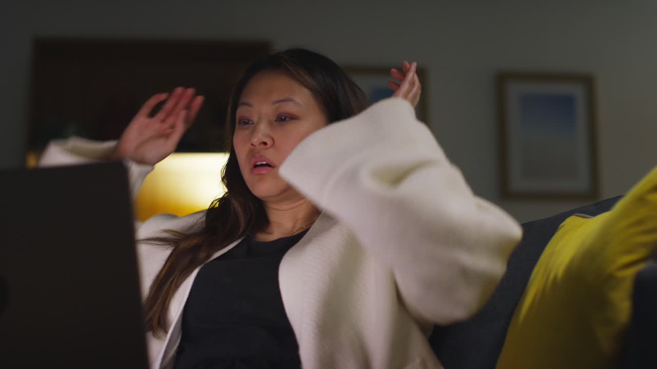 집에서 소파에서 노트북을 쓰고 있는 여자