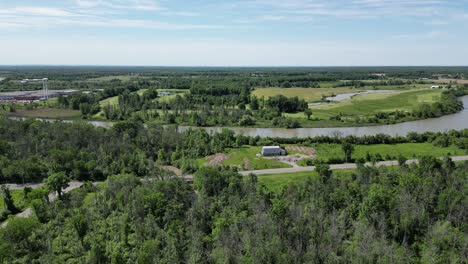 Barn-near-river-and-golf-course,-aerial-countryside-of-Niagara-region