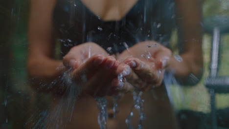 woman in shower catching water in hands enjoying refreshing cleanse showering outdoors in nature