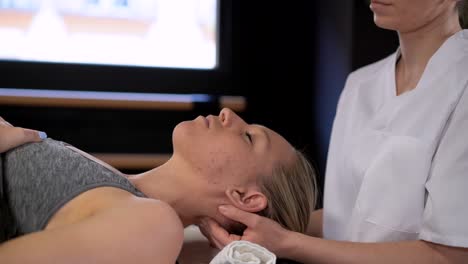 Female-therapist-massaging-head-of-patient