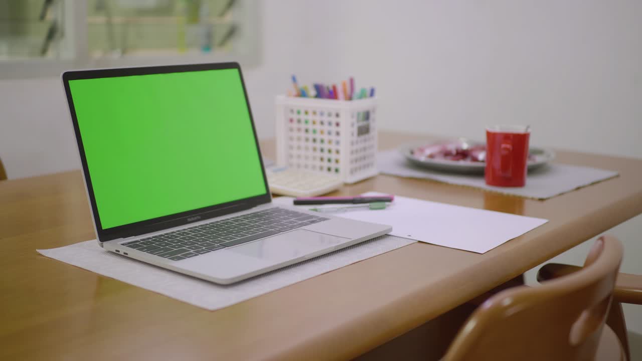 fotografía deslizante de una computadora portátil de pantalla verde de pie en el escritorio