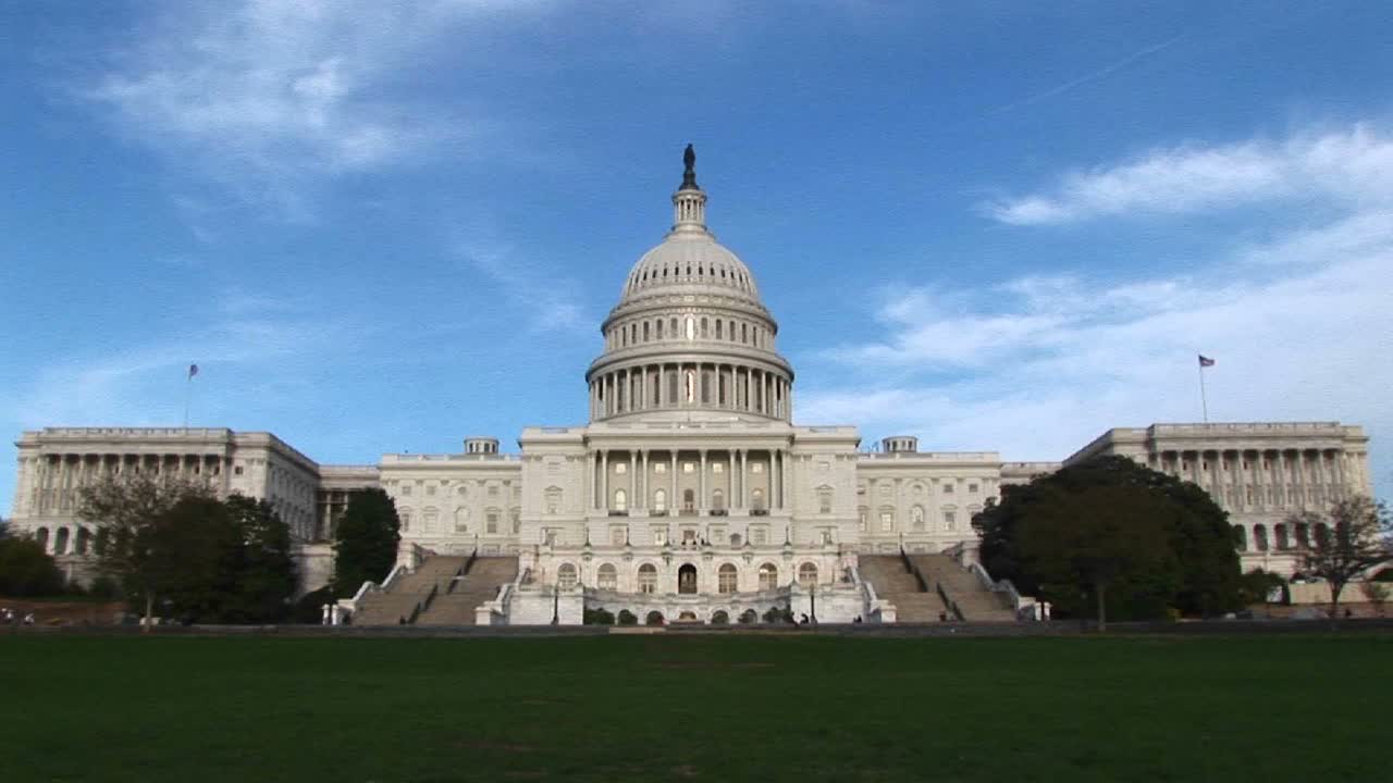 desde una toma larga de la fachada este del edificio del capitolio de estados unidos en washington dc, la cámara se acerca a la histórica rotonda del edificio y a la singular cúpula de hierro