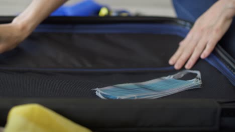 video of woman packing a protective mask into a suitcase