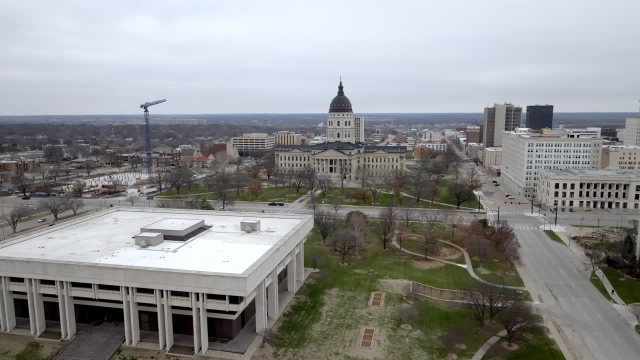 Kansas' delstatsregeringsbygning med flag der vajer i vinden i Topeka, Kansas, med en dronevideo, der cirkulerer et vidvinkelbillede.