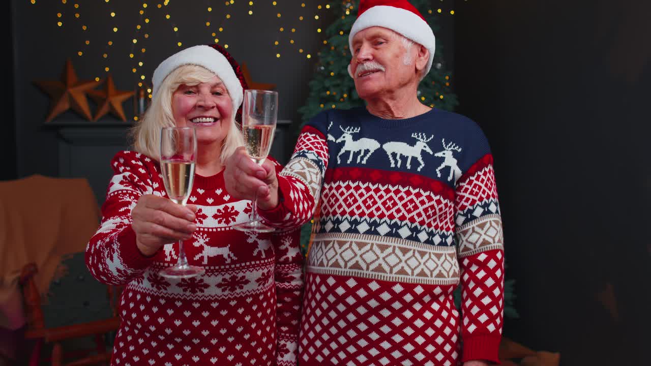 집에서 크리스마스를 축하하고 안경을 부딪치며 샴페인을 마시는 즐거운 노부부