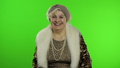 elderly stylish grandmother. caucasian woman waves her hands, greets. chroma key