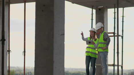 Construction-worker-and-engineer-talking-at-construction-site-site.-Workers-in-helmets-at-building-area.-Portrait-of-construction-engineers-working-on-building-site.-concept-of-modern-construction