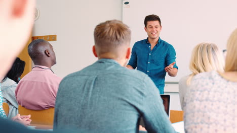 rear view of mature college student asking question in class