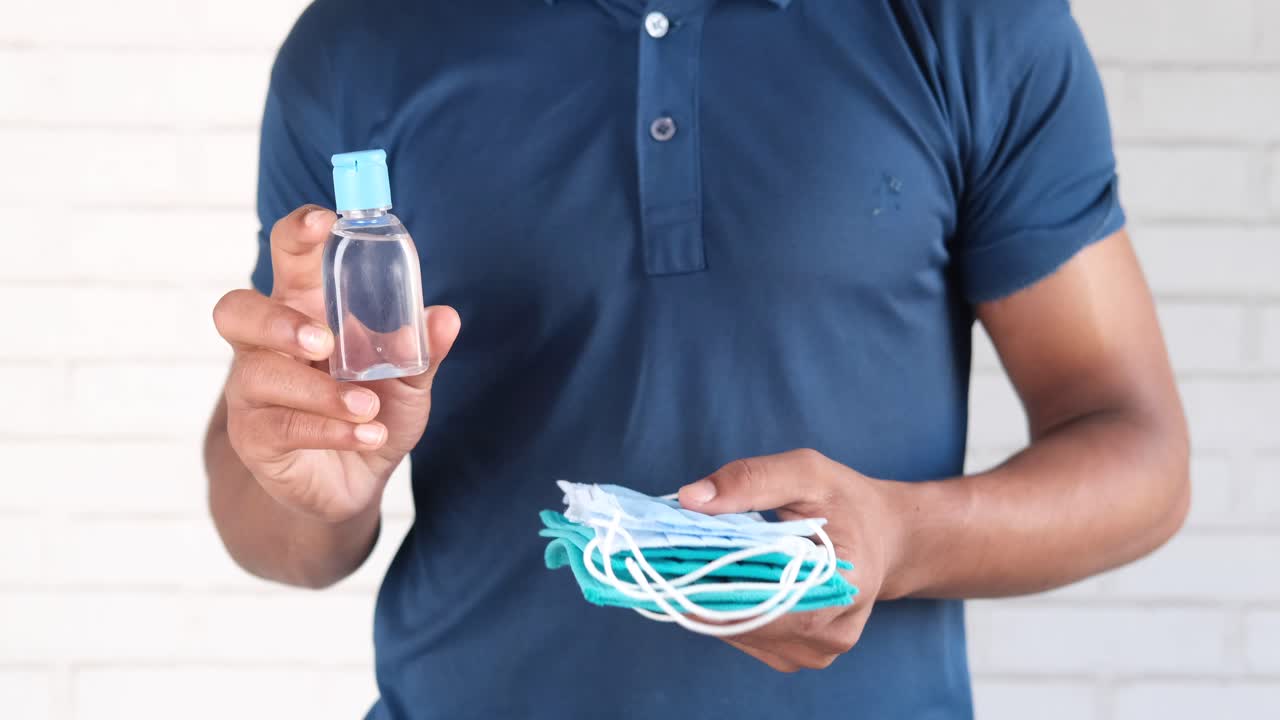 persona con desinfectante para manos y máscaras faciales