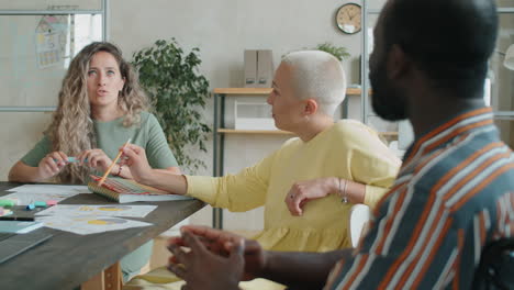 businesswoman speaking with colleague in wheelchair at office meeting