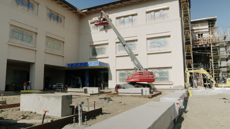 construction site with a large building, boom lift, and scaffolding