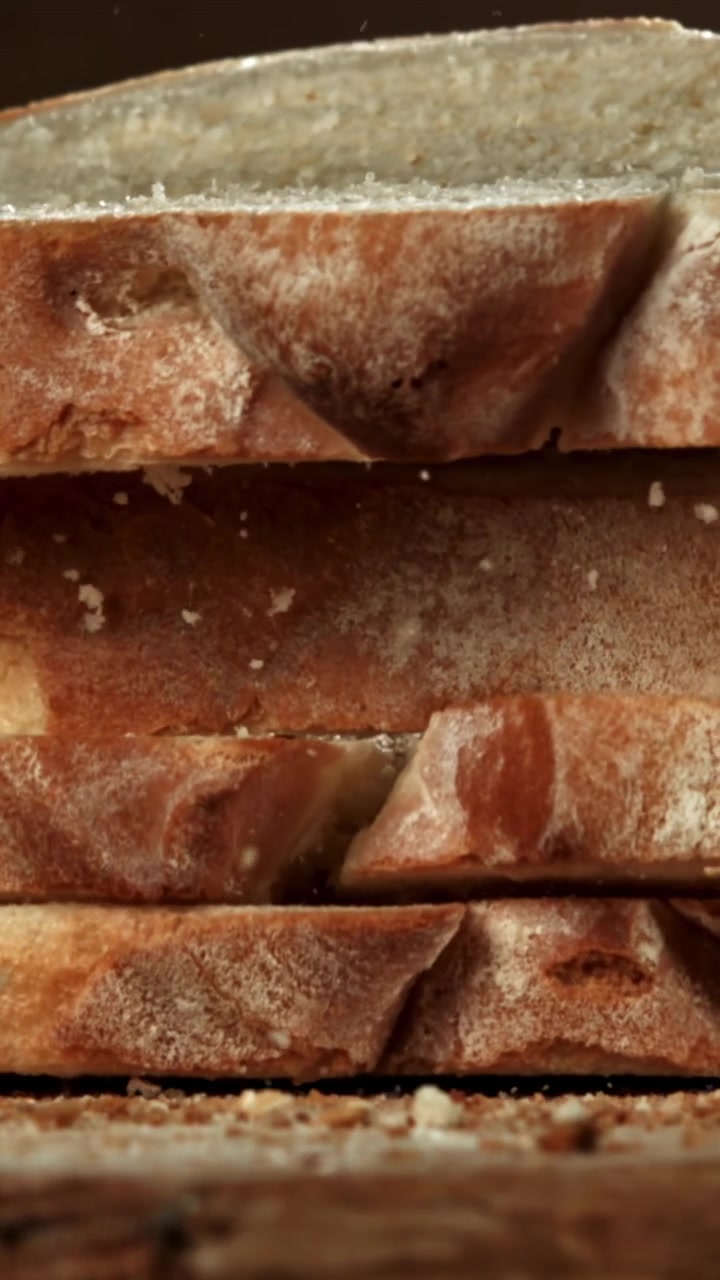 Primo piano al rallentatore di fette di pane fresco che cadono e si impilano