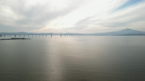 drone descends to water with richmond bridge from point molate beach richmond california usa
