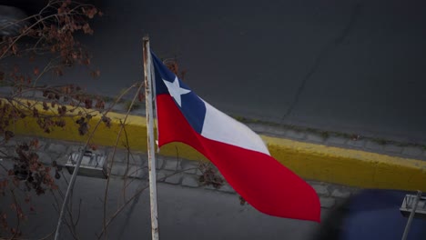 chilean flag on pole with traffic in the background