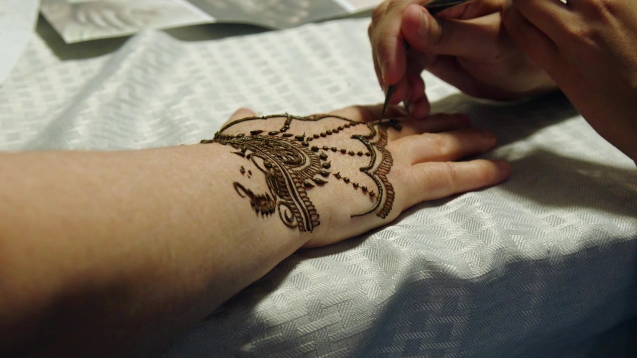 Primo piano: disegno all'henné Mehendi disegnato sul dorso della mano di una donna.