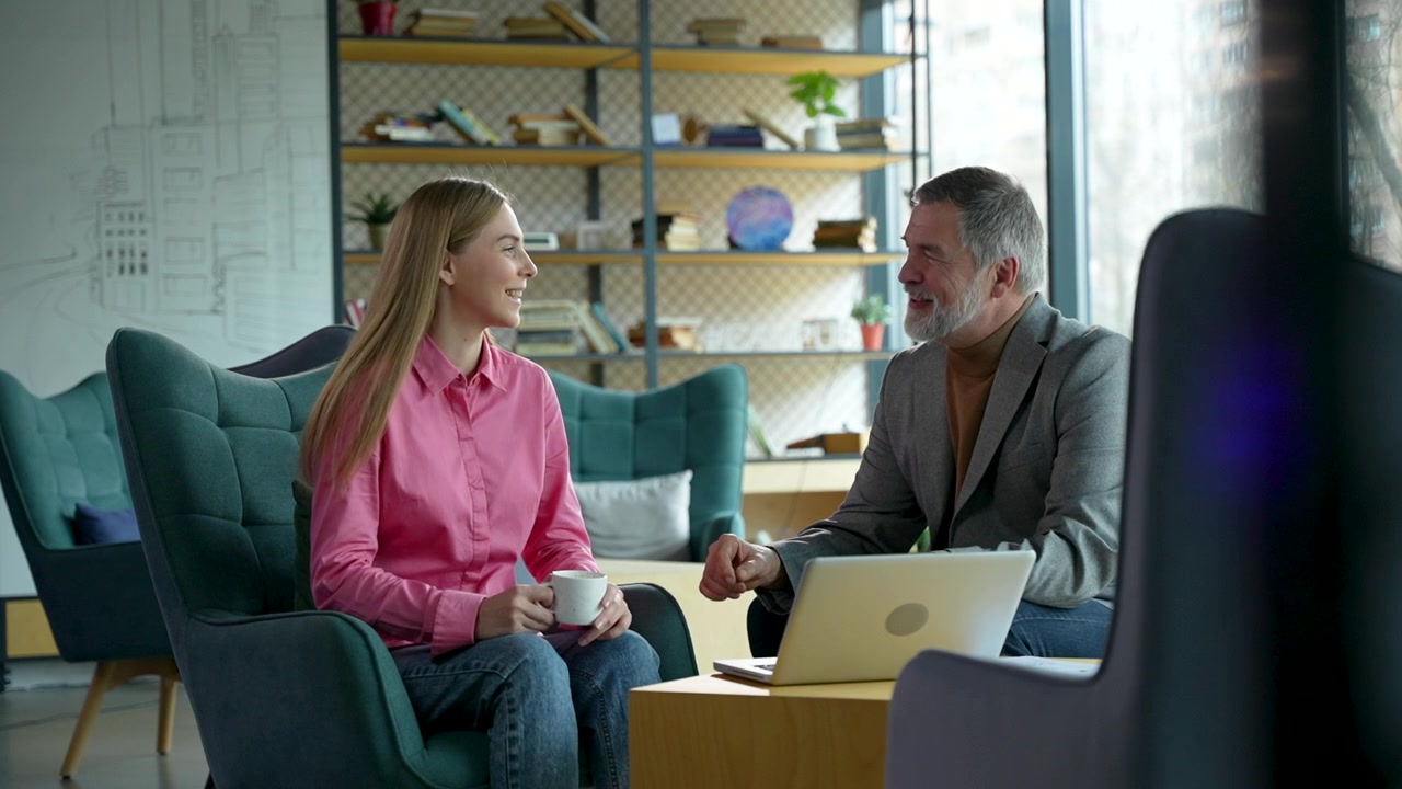 Professional Business Meeting Between Young Woman and Mature Man in Modern Office